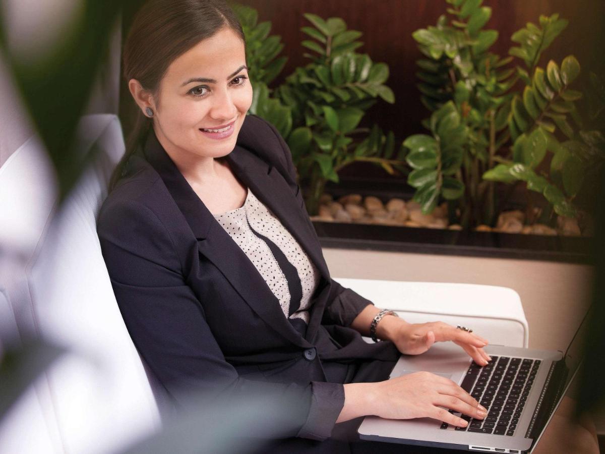 Movenpick Jumeirah Village Triangle Dubai Exterior foto A business woman working on a laptop